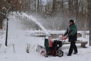 Man in Green Jacket Using Snow Blower